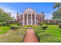 Stately brick home with white columns and trim sits at the end of brick path through manicured lawn at 5002 S Shore Crest Cir, Tampa, FL 33609