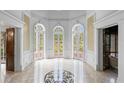 Grand foyer with marble floors, arched doorways, decorative wallpaper and large glass doors to exterior at 5002 S Shore Crest Cir, Tampa, FL 33609