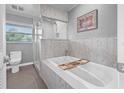 Relaxing primary bathroom featuring a shower and soaking tub, with modern white tiling at 5080 43Rd S St, St Petersburg, FL 33711