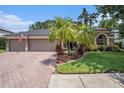 Charming home with a brick driveway, complemented by tropical landscaping and a serene residential neighborhood at 5101 Hartwell Loop, Land O Lakes, FL 34638