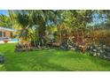 Serene backyard garden featuring lush greenery, mature trees, and inviting wooden benches for relaxation at 5835 29Th N Ave, St Petersburg, FL 33710