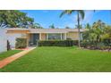 Well-kept single story home featuring a lush green lawn and mature landscaping enhancing the property's curb appeal at 5835 29Th N Ave, St Petersburg, FL 33710