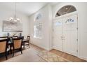 Bright entryway featuring double doors, arch windows, elegant lighting, and wood flooring at 6212 Nimes Ct, Lutz, FL 33558