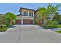 Elegant two-story home with a front balcony, attached two-car garage, and manicured landscaping at 6913 Park Strand Dr, Apollo Beach, FL 33572