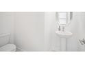 Clean half bathroom featuring a modern sink and toilet, perfect for guests at 7703 S Kissimmee St, Tampa, FL 33616