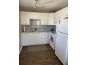 Modern kitchen with sleek white cabinets, gray backsplash, and updated appliances at 8455 112Th St # 212, Seminole, FL 33772