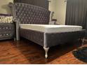 Main bedroom boasts hardwood floors, a tall velvet headboard, and matching nightstand at 10980 104Th Ave, Largo, FL 33778
