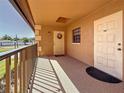Balcony view showcasing condo doors with clear unit number, exterior lighting, and shaded area at 12900 Vonn Rd # D202, Largo, FL 33774