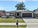 Inviting single-story home showcasing a neatly maintained lawn and an attached two-car garage at 1948 Citrus Hill Ln, Palm Harbor, FL 34683