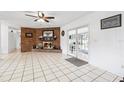 Cozy living room featuring a brick fireplace, tiled floors, and glass doors to bring in natural light at 2013 Capri Rd, Valrico, FL 33594
