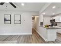 Open-concept living space with sleek floors, neutral walls, and a breakfast bar connecting to the kitchen at 2230 Melrose S Ave, St Petersburg, FL 33712