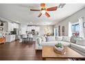 Open-concept living room featuring hardwood floors and plenty of natural light from multiple windows at 2829 Maple Brook Loop, Lutz, FL 33558