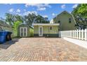 Exterior home showing a brick driveway, shed, and fenced yard at 301 81St Ne Ave, St Petersburg, FL 33702