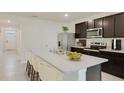 Kitchen with dark cabinetry, stainless appliances, quartz countertops, island with bar seating at 35121 Valley Ridge Rd, Dade City, FL 33525
