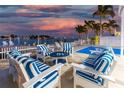Cozy patio with striped seating, a waterfront view, and a fence leading to a boat dock at 474 20Th Ave, Indian Rocks Beach, FL 33785