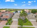 Aerial shot of home showing tile roof and a serene water view in a neighborhood with manicured lawns and trees at 5009 Sandy Brook Cir, Wimauma, FL 33598