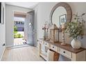 Inviting entryway with a decorative console table, round mirror, and light wood-look flooring at 520 Valri Park Dr, Valrico, FL 33594