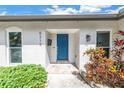 Inviting front entrance featuring a vibrant blue door and meticulously landscaped surroundings at 5215 Denver Ne St, St Petersburg, FL 33703