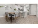 Bright dining area features wood-look tile, modern table setting, and open flow to the kitchen at 5270 Neil Dr, St Petersburg, FL 33714