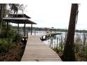 Scenic lake view featuring a charming gazebo extending from a wooden walkway at 6160 Fitzgerald Road, Odessa, FL 33556