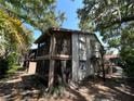 Condo building exterior with screened balconies and stairs amidst mature trees and landscaping at 647 Fairmont Ave # C, Safety Harbor, FL 34695