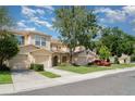 Neighborhood street featuring well-kept townhomes with attached garages, lush trees, and sidewalks, all under a clear blue sky at 6954 Hawthorne Trace Ln, Riverview, FL 33578