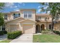 Inviting townhome with a one-car garage and a neatly landscaped yard, under a bright blue sky with scattered clouds at 6954 Hawthorne Trace Ln, Riverview, FL 33578