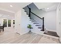Foyer with tile flooring, staircase with dark wood railings, and views into dining area at 768 Pinellas Point S Dr, St Petersburg, FL 33705
