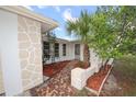 Charming front entrance with brick walkway, fresh mulch landscaping, and stylish stone accents at 7904 Judith Cres, Port Richey, FL 34668
