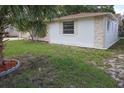 View of the home's front lawn and exterior showing stone accents, window and well-maintained landscaping at 7904 Judith Cres, Port Richey, FL 34668