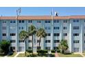 Exterior shot of a multi-story building with lawn and palm trees in front at 801 83Rd N Ave # 209, St Petersburg, FL 33702