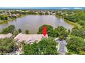 An aerial view of the property and lake, surrounded by lush trees and ample parking at 8576 Sandy Beach St, Tampa, FL 33634