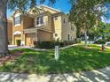 A two story townhome is landscaped with green grass and neatly trimmed bushes at 8576 Sandy Beach St, Tampa, FL 33634