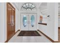 Elegant entryway showcases double doors with decorative glass, tile flooring, and natural light at 8827 Scout Lake Ct, New Port Richey, FL 34654