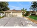 Charming single-story home with a lush lawn, palm trees and a three-car garage at 9408 Sayre St, Riverview, FL 33569