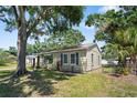 Charming single-story home with manicured lawn, mature trees, and a fenced yard at 1013 N Bask Dr, Tampa, FL 33603