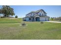 Landscaped lawn surrounds this beautiful two-story home with stone accents at 10517 Crestview Heights Ave, Thonotosassa, FL 33592