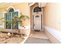 Close-up of the home's entrance featuring a white front door and an arched window above at 1126 Haley Ln, Dunedin, FL 34698