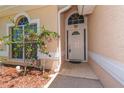 Inviting front entrance with landscaped garden and charming white door with transom window at 1126 Haley Ln, Dunedin, FL 34698