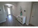 Inviting entryway features elegant decor, a decorative cabinet, and stylish chandelier and gray wood floors at 13103 Monach Isles Dr, Riverview, FL 33579