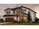 Charming two-story home with stone accents, a tile roof, manicured lawn and a convenient 2-car garage at 13722 Heartwood Way, Parrish, FL 34219