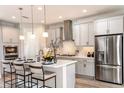 Modern kitchen with stainless steel appliances, a center island with bar seating, and sleek gray cabinets at 13722 Heartwood Way, Parrish, FL 34219