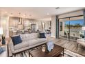 Open-concept living room flowing into kitchen, with wood floors and glass doors leading to an outdoor patio at 13722 Heartwood Way, Parrish, FL 34219