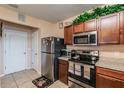 The kitchen shows stainless steel appliances and wood cabinets at 14560 Haddon Mist Dr, Wimauma, FL 33598