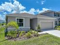 A single Gathering home has a grey shingle roof, stone accents, and manicured lawn at 152 Bright Ibis Ave, Apollo Beach, FL 33572