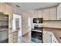 Bright kitchen featuring white cabinetry, appliances, and a glimpse of the entryway at 1920 E Chelsea St, Tampa, FL 33610