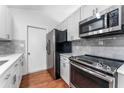 Well-appointed kitchen featuring stainless steel appliances, white cabinets, and quartz countertops at 2313 Palm Ave, Seffner, FL 33584