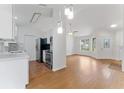 Open-concept living area with hardwood floors, modern lighting, and stainless steel kitchen appliances at 2313 Palm Ave, Seffner, FL 33584