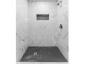 Elegant shower with marble-patterned walls and a contrasting black tile floor at 2313 Palm Ave, Seffner, FL 33584