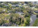 A captivating aerial view captures the home's position on the canal, amidst verdant trees and neighboring residences at 2416 S 46Th St, Tampa, FL 33619